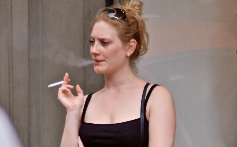 Sassy strawberry blonde in black top on a smoke break